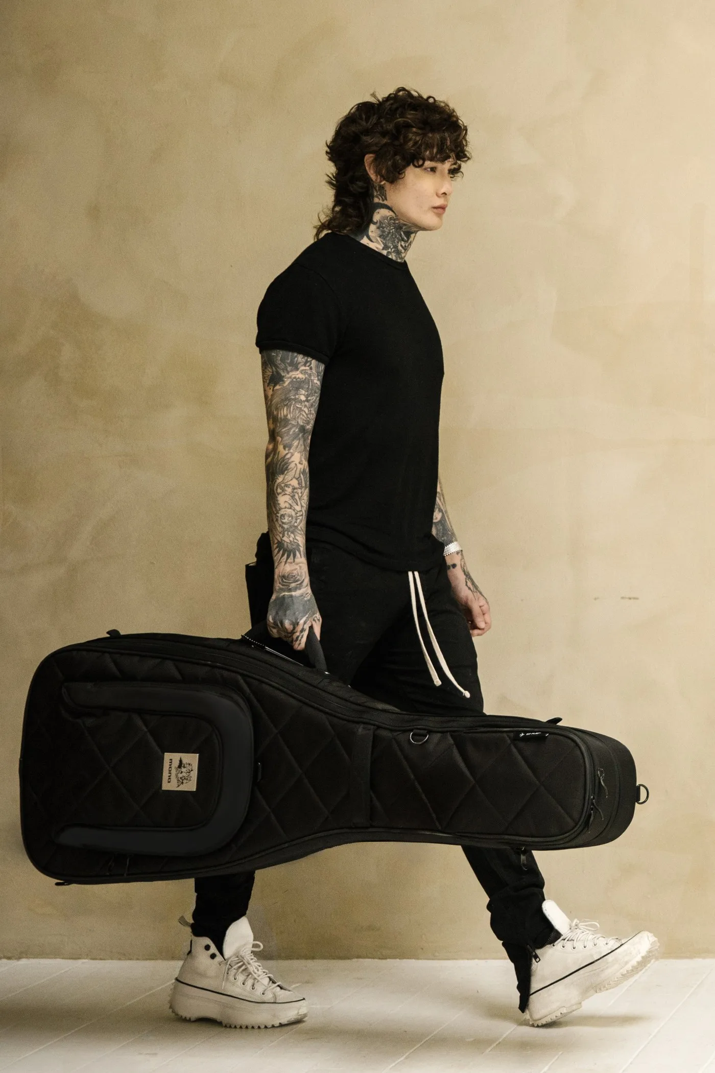 Tim Henson carrying the MONO × Tim Henson dual case by its front handle